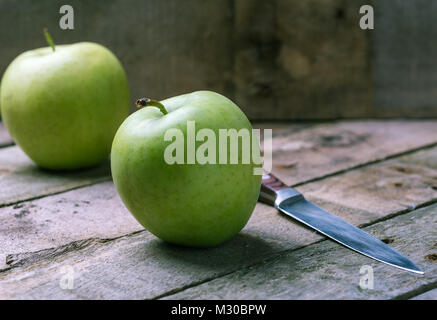 Green Apple avec le couteau en bois sur 24 naturelles. Banque D'Images