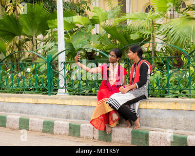 Mysore, Karnataka, Inde. Le 11 janvier 2018. Portrait de filles habillées traditionnellement en tenant sur selfies smartphone. Banque D'Images