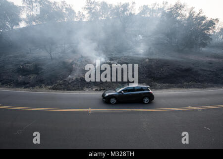 Une voiture conduit par un brûle encore hill à Ojai, en Californie, le 12 décembre 2017. Thomas le feu a commencé le 4 décembre 2017 à Santa Paula, près de Thomas Aquinas College. Entraîné par les vents de Santa Ana avec rafales jusqu'à 70 mi/h, les flammes crié à travers le flanc à Ojai, Ventura et Santa Barbara. L'Airlift Wing 146 a été activé Dec.5, 2017, à l'appui de CAL FIRE avec suppression des feux de forêt, les efforts déployés au sein de l'état. (U.S. Air Force photo/Master Sgt. Brian Ferguson (États-Unis) Air Force photo/Master Sgt. Brian Ferguson) 171212-F-BP133-115.jpg par AirmanMagazine Banque D'Images