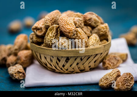Close up de matières sèches Dattes,Phoenix dactylifera dans un bol sur une surface en bois. Banque D'Images
