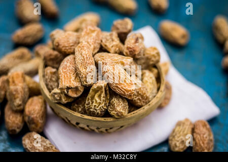 Close up de matières sèches Dattes,Phoenix dactylifera dans un bol sur une surface en bois. Banque D'Images
