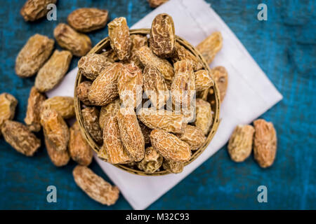 Close up de matières sèches Dattes,Phoenix dactylifera dans un bol sur une surface en bois. Banque D'Images