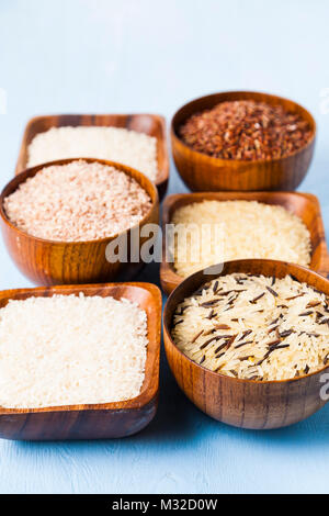 6 bols avec différentes variétés de riz sur un fond de bois. Ingrédient pour un régime alimentaire sain. Banque D'Images