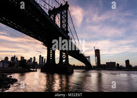 Magnifique coucher de soleil sur le pont de Manhattan et le quartier financier de Manhattan à travers l'East River à partir de Brooklyn à New York City, USA Banque D'Images