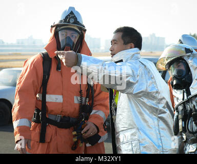 Kazuyuki Rolande Depoortere, un pompier du 374e Escadron de génie civil, se traduit par des ordres à un pompier avec la Japan Air Self-Defense Force à Yokota Air Base, Japon, le 23 janvier 2014. Partenariat bilatéral est crucial pour assurer la sécurité de la communauté. (U.S. Air Force photo par un membre de la 1re classe Meagan Schutter/libérés) traduit les ordres à un pompier à la Japan Air Self-Defense Force. Partnershi bilatérales par # PACOM Banque D'Images