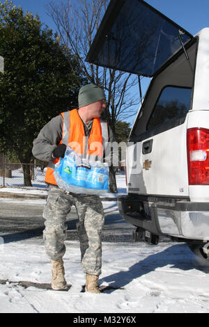 Lac de l'ouest de MARTA STATION, Atlanta, Géorgie, le 30 janvier 2014 - Armée de la Géorgie Garde Nationale Le s.. Dustin Haley, un surveillant de l'entretien avec le 201e groupe d'appui régional, charge l'eau en bouteille à l'arrière d'un camion à quatre roues motrices à l'appui des résidents de la Géorgie qui ont besoin d'aide pour récupérer leurs véhicules abandonnés après la tempête de neige qui a frappé Atlanta mardi. (U.S. La Garde nationale de l'armée photo par le Sgt. Michael Uribe/relâché). Les géorgiens d'aider les Géorgiens par la Garde nationale de Géorgie Banque D'Images