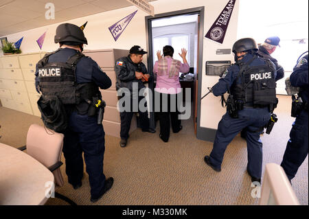 L'agent de sécurité du camp Mabry Jimmy Jean, ainsi que des membres de la Police d'Austin's Counter Strike Team Assualt (CAST), est disposée comme un acteur quitte son bureau à un tireur actif scénario de formation s'est déroulée au Camp Mabry à Austin, Texas, le 19 mars 2014. Les agents de sécurité du camp et d'employés formés avec le CAST de répéter des scénarios de tireurs actifs afin de mieux se préparer à cet événement. (U.S. La Garde nationale de l'armée photo par le Sgt. 1re classe Malcolm McClendon). 140319-Z-FG822-004 par Texas Département militaire Banque D'Images