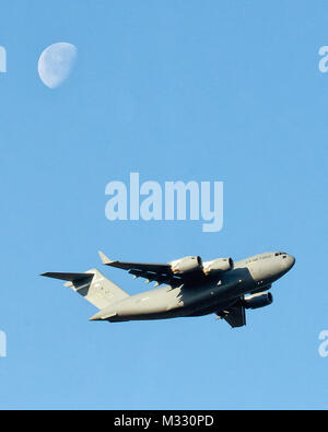 Un C-17 Globemaster III à partir de la 3e Escadre, Joint Base Elmendorf-Richardson décolle à Yokota Air Base, Japon, le 22 mars 2014. L'aéronef a marqué le premier C-17 à l'atterrissage à l'aéroport de Sendai après le séisme et le tsunami du 11 mars 2011. (U.S. Air Force photo par Yasuo Osakabe/libérés) C-17 avec lune par # PACOM Banque D'Images