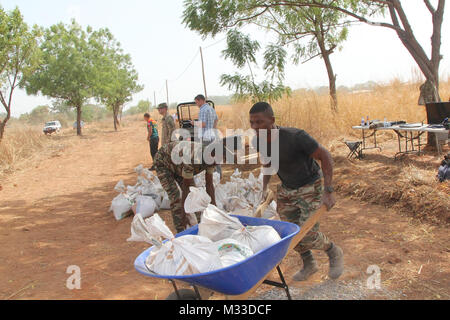 Darby Task Force des soldats de 1er Bataillon, 87e Régiment d'infanterie, 1e Brigade Combat Team, 10e division de montagne, TF Darby et membres de la Base Aérienne 301 Camerounais aviateurs participent à l'Do-Nou Road Le 25 janvier, près de l'emplacement d'urgence Garoua, Cameroun. Le projet utilise des sacs pour réparer les routes qui ont tendance à se laver pendant la saison des pluies. Les dirigeants locaux également le projet pour voir si le Do-Nou méthode peut être utile pour leurs propres projets de réparation des routes. Darby TF sont des soldats servant dans un rôle de soutien pour la lutte contre les militaires du Cameroun l'organisation extrémiste violent Boko H Banque D'Images