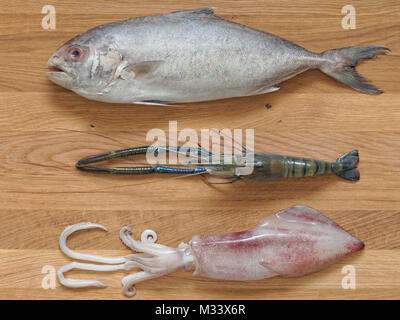 Mélanger les fruits de mer, black-banded Lactarius poissons, crevette, et la seiche, isolé sur fond planche à découper en bois Banque D'Images