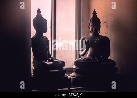 Abstract light image clé faible face de statue de Bouddha en laiton avec rayon de soleil à travers de la fenêtre. Banque D'Images
