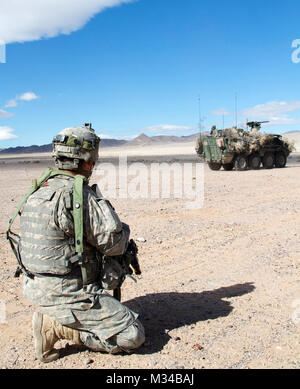 La FPC. Michael Long, normalement un bras pour l'exploitant de mines Déminage Buffalo véhicule protégé (MPCV) avec la société B, 6e bataillon du génie de la Brigade, 4e Brigade Combat Team (Airborne), 25e Division d'infanterie basée à Joint Base Elmendorf-Richardson, Alaska et originaire de Santa Cruz, Californie, tire la sécurité comme un 1er Stryker Brigade Combat Team "Le loup arctique" Stryker passe par le 31 janvier 2015. 6e BEB est l'une des nombreuses unités de l'ensemble de l'armée pour collaborer avec le premier SBCT "Loup arctique" sur leur instruction préalable au déploiement de la mission de validation au Centre National d'entraînement à Fort Irwin, en Californie (États-Unis Banque D'Images