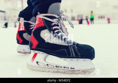 À jambes patineur patinoire. Couleur noire des patins. Les jambes dans un pantalon noir dans le patinage sur glace. Passe-temps sports amateurs. vieux sports patins. sur la jambe d'un homme Banque D'Images