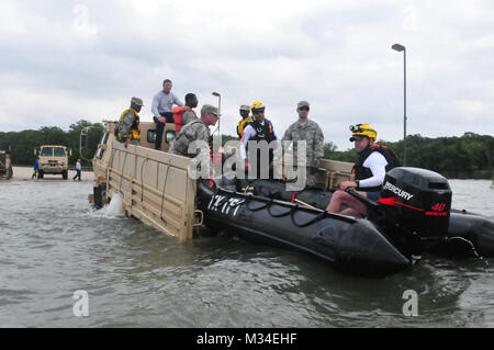 Les soldats de la Garde nationale de l'armée du Texas sur l'état du service actif, effectuer des répétitions de sauvetage de l'eau avec les premiers intervenants de la Texas Task Force 1 (TXTF-1), alors que sur la mise en veille pour répondre aux inondations dans la région du nord du Texas, le 16 mai 2015. Garde fournis léger moyen pour les véhicules tactiques disposer TXTF-1 dans les eaux des bateaux gonflables de simuler des victimes des inondations de sauvetage dans des conditions contrôlées. Garde travaillent souvent côte à côte avec des partenaires locaux et de l'Etat pour aider les Texans en ont besoin pendant les situations de catastrophe. (U.S. La Garde nationale de l'armée photo : Capt Maria Mengrone) 150516-Z-OK423-111 par T Banque D'Images