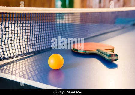 Tennis de table - racket, ball, table. Raquettes de ping-pong ou au ping-pong et boules jaune sur bleu table. Sport concept. Tennis de Table Banque D'Images