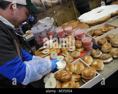 Les employés de l'Acme fumoir à poisson Le poisson fumé et le bagel Bagel's Zucker fabricant et le poisson fumé la construction d'un bagel au saumon de dimensions excédentaires avec fromage à la crème, saumon, tomates, oignons et câpres à New York, USA, 09 février 2018. Photo : Johannes Schmitt-Tegge/dpa Banque D'Images