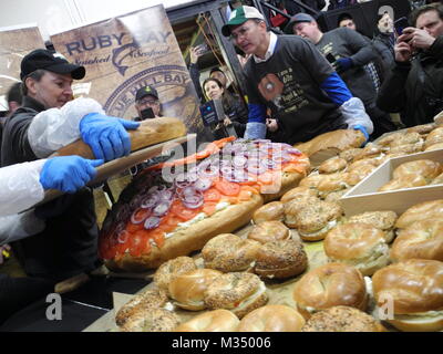 Les employés de l'Acme fumoir à poisson Le poisson fumé et le bagel Bagel's Zucker fabricant et le poisson fumé la construction d'un bagel au saumon de dimensions excédentaires avec fromage à la crème, saumon, tomates, oignons et câpres à New York, USA, 09 février 2018. Photo : Johannes Schmitt-Tegge/dpa Banque D'Images