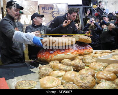 Les employés de l'Acme fumoir à poisson Le poisson fumé et le bagel Bagel's Zucker fabricant et le poisson fumé la construction d'un bagel au saumon de dimensions excédentaires avec fromage à la crème, saumon, tomates, oignons et câpres à New York, USA, 09 février 2018. Photo : Johannes Schmitt-Tegge/dpa Banque D'Images