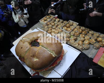 Les employés de l'Acme fumoir à poisson Le poisson fumé et le bagel Bagel's Zucker fabricant et le poisson fumé la construction d'un bagel au saumon de dimensions excédentaires avec fromage à la crème, saumon, tomates, oignons et câpres à New York, USA, 09 février 2018. Photo : Johannes Schmitt-Tegge/dpa Banque D'Images