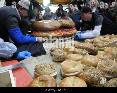 Les employés de l'Acme fumoir à poisson Le poisson fumé et le bagel Bagel's Zucker fabricant et le poisson fumé la construction d'un bagel au saumon de dimensions excédentaires avec fromage à la crème, saumon, tomates, oignons et câpres à New York, USA, 09 février 2018. Photo : Johannes Schmitt-Tegge/dpa Banque D'Images