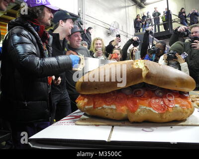 Les employés de l'Acme fumoir à poisson Le poisson fumé et le bagel Bagel's Zucker fabricant et le poisson fumé la construction d'un bagel au saumon de dimensions excédentaires avec fromage à la crème, saumon, tomates, oignons et câpres à New York, USA, 09 février 2018. Photo : Johannes Schmitt-Tegge/dpa Banque D'Images