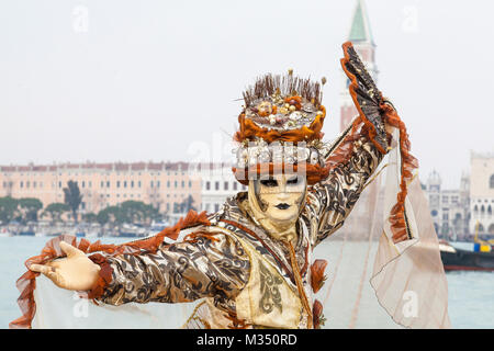 Venise, Vénétie, Italie, 9 février 2018. Costumes colorés et des masques lors des fêtes d'aujourd'hui malgré les mauvaises conditions météorologiques. Photo prise sur l'Isola San Giorgio Maggiore avec sea mist. Banque D'Images