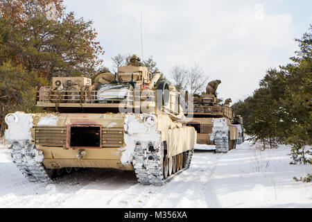 Marines avec la société F, 4e Bataillon, 4e Division de marines, pause avant l'acheminement à un secteur d'entraînement pendant les vacances d'hiver 2018 de l'exercice près du camp de l'Arctique, Michigan, le 8 février 2018. Au cours de la formation du deuxième jour de congé d'hiver 18, Fox Co. marines répétées formations, menées de la navigation terrestre avancée et d'identification de terrain et effectué les vérifications d'entretien préventif et les services sur leurs véhicules blindés et du matériel tout en augmentant leur capacité opérationnelle dans la seule mesure des températures et de la neige. Banque D'Images