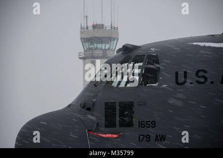 Travail sur le frein aviateurs systèmes d'un C-130H Hercules lors d'une tempête de neige, Février 07, 2018, à la 179e Airlift Wing, Mansfield, Ohio. La 179e Airlift Wing groupe maintenance inspecte régulièrement tous les aspects de leur avion pour maintenir l'état de préparation de la mission avec prêt d'aviateurs et de prêt des avions. (U.S. Air National Guard Banque D'Images