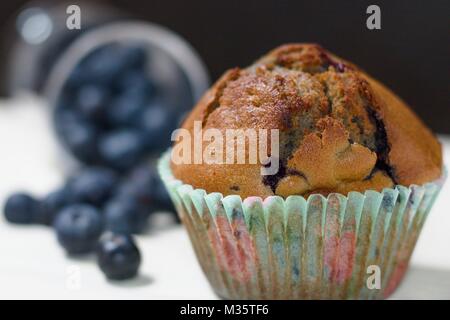 Sans gluten maison cupcake blueberry sur table blanche et fond noir. Verre renversé de bleuets en arrière-plan Banque D'Images