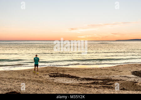 Un homme commence à exercer au coucher du soleil sur la Playa de Palma, Palma de Mallorca, Majorque, Espagne. Banque D'Images