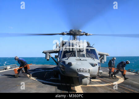 150717-N-BX824-085 mer de Timor (17 juillet 2015) marins déposer des cales et de chaînes d'un MH-60S Seahawk de la 'Golden Falcon' de la mer d'hélicoptères de l'Escadron de Combat (HSC) 12 dans le poste de pilotage de la classe Ticonderoga à guidage de missiles cruiser USS ANTIETAM (CG 54) au cours de Talisman Saber (TS) 2015. TS 15 est un exercice biennal qui fournit une occasion inestimable pour près de 30 000 des Forces de défense australiennes et américaines de mener des opérations dans un environnement interarmées et interinstitutions, qui permettront d'accroître la capacité des deux pays de planifier et d'exécuter une gamme complète d'opérations de missions de combat à hu Banque D'Images