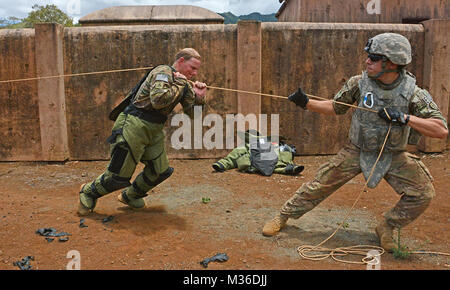 SCHOFIELD BARRACKS, Virginia- membres de l'équipe de neutralisation des explosifs et des 65e, 303e Bataillon de la société NEM, 8e Brigade de police militaire, 8ème commande Soutien Théâtre, tirer sur une corde pour effacer des éléments du tronc d'une voiture qui a un dispositif explosif à l'intérieur durant l'équipe de neutralisation des Army-Pacific américain de l'année, du 11 au 15 juillet. (U.S. Photo de l'armée par le sergent. Taresha Hill, 8e Brigade de police militaire, des affaires publiques de la 8e commande Soutien Théâtre) compétences testées à Army-Pacific aux États-Unis des explosifs et des munitions de l'équipe de l'année par la concurrence # PACOM Banque D'Images