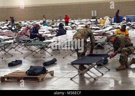 Des soldats de la Garde nationale de la Louisiane à la Compagnie de la Police militaire du 2228th situé à Alexandria mise en place des lits bébés à l'intérieur de la Baton Rouge River Center le 15 août 2016 après d'importantes inondations les a poussés à leurs foyers au cours des derniers jours.. Guardsman ici aident également la police d'état de la Louisiane avec la sécurité. (U.S. Photo de la Garde nationale par la CPS. Garrett L. Dipuma/libérés) Inondations du Sud 160815-Z-PJ019-010 par la Garde nationale de la Louisiane Banque D'Images