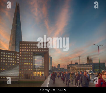 Les employés de bureau de la ville de London Bridge à l'heure de pointe du matin avec le tesson gratte-ciel en arrière-plan contre nuages colorés. Banque D'Images