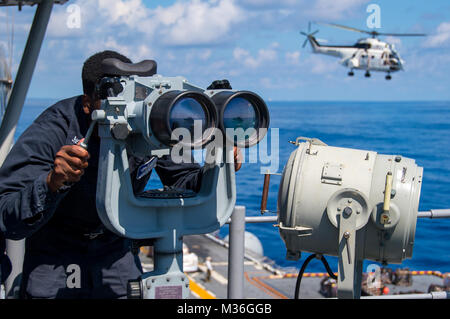 161003-N-E560-208 HONG KONG (oct. 3, 2016) Maître de 3e classe Monteco Salley, de Charlestown, S.C., sondages l'horizon à l'aide de "grands yeux" jumelles à bord de navire d'assaut amphibie USS Bonhomme Richard (DG 6) au cours d'un ravitaillement en mer (RAS). Bonhomme Richard, navire amiral du Bonhomme Richard, groupe expéditionnaire est opérant dans le sud de la mer de Chine à l'appui de la sécurité et de la stabilité dans la région du Pacifique Indo-Asia. (U.S. Photo de la marine par le maître de 3e classe Jeanette Mullinax/libérés) Assurer une veille dans le cadre de ravitaillement en mer à bord du USS Bonhomme Richard par # PACOM Banque D'Images