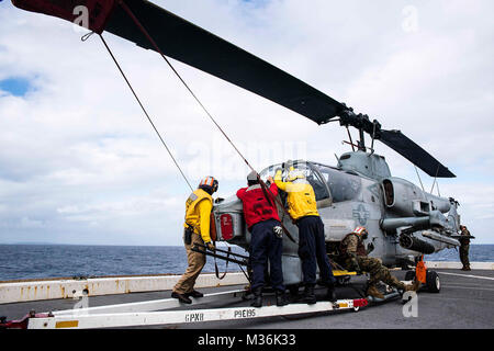 Mer de Chine orientale (janv. 29, 2017) Les marins à bord de la station de transport amphibie USS Green Bay (LPD 20) et les Marines affectés à l'escadron à rotors basculants moyen maritime (VMM) 262 (renforcée) déplacer un AH-1W Super Cobra helicopter sur Green Bay de lancement. Green Bay est à une patrouille de routine, opérant dans la région du Pacifique-Indo-Asia pour renforcer les partenariats et d'être un prête-réponse vigueur pour tout type d'imprévus. (U.S. Photo par marine Spécialiste de la communication de masse 1re classe Chris Williamson/libérés) marines, les marins travaillent ensemble pour transporter à bord d'aéronefs USS Green Bay par # PACOM Banque D'Images