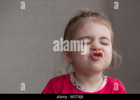 Clouse-up portrait of smiling little girl making funny grimace et gestes à l'appareil photo. Avez-vous souri aujourd'hui Banque D'Images