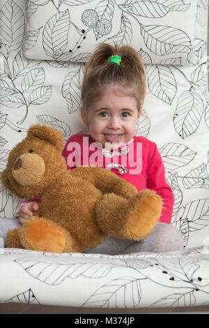 Clouse-up portrait of smiling little girl making funny grimace et gestes à l'appareil photo. Banque D'Images