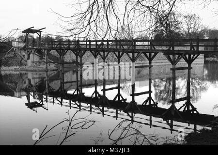 Pont-levis en bois se reflétant dans les douves du château de Sully, France Banque D'Images