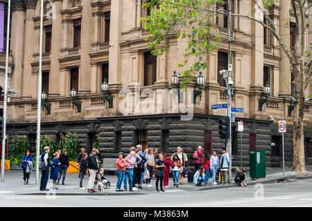 Les piétons qui traversent la rue Collins à l'angle avec la rue Swanston, avec l'hôtel de ville derrière, Melbourne, Victoria, Australie Banque D'Images