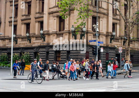 Les piétons qui traversent la rue Collins à l'angle avec la rue Swanston, avec l'hôtel de ville derrière, Melbourne, Victoria, Australie Banque D'Images