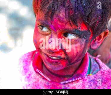 Un petit garçon couvert de peinture en poudre au cours de la célébration de l'Hindu Holi festival du printemps à New Delhi, en Inde. Banque D'Images