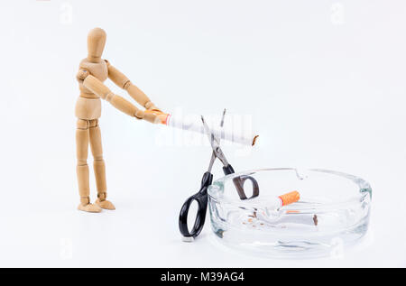 Marionnette en bois Utilisez des ciseaux pour couper la cigarette dans le cendrier.Ne pas fumer Jour contexte.Anti fumeurs Banque D'Images