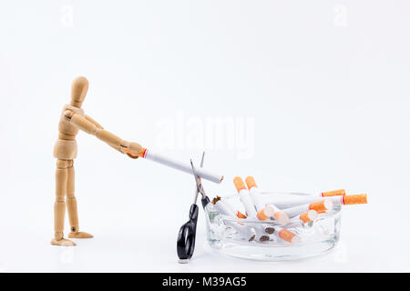 Marionnette en bois Utilisez des ciseaux pour couper la cigarette dans le cendrier.Ne pas fumer Jour contexte.Anti fumeurs Banque D'Images
