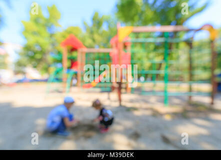 Les enfants jouent dans le sable près de l'aire de jeux. Abstract image floue en arrière-plan Banque D'Images