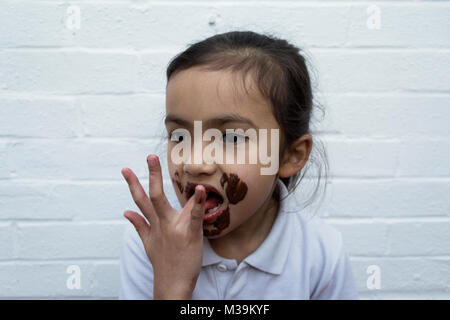 Enfant de manger du chocolat avec désordre sur face Banque D'Images