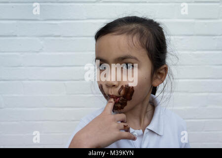 Enfant de manger du chocolat avec désordre sur face Banque D'Images