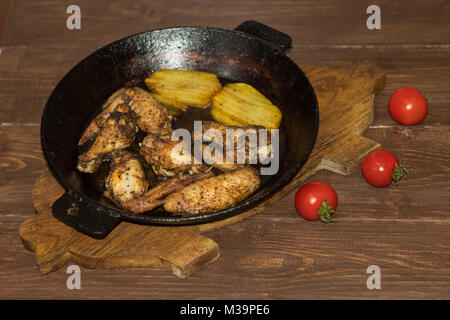 Ailes de poulet avec pommes de terre frites dans une casserole Banque D'Images