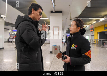 Nanjing, Jiangsu Province de la Chine. Feb 9, 2018. Deyu Chen (L) indique à l'intendant de ses renseignements sur le train à la gare du sud de Nanjing à Nanjing, capitale de la province de Jiangsu, Chine orientale, le 9 février 2018. Deyu Chen, un masseur aveugle né en 1988, a bénéficié de l'aide de la '158' groupe de service volontaire de la gare du sud de Nanjing de Nanjing dans sa ville natale dans la province d'Anhui. Le groupe, créé en 1968, vise à aider ceux qui en ont besoin sur leurs cours. Crédit : Li Bo/Xinhua/Alamy Live News Banque D'Images