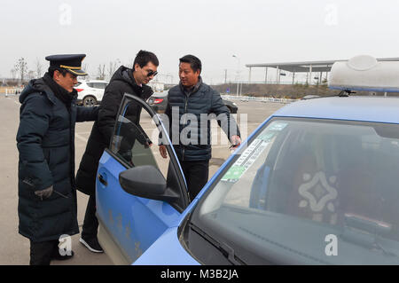 Nanjing, Chine, Anhui Province. Feb 9, 2018. Deyu Chen (C) prend un taxi avec l'aide d'un délégué syndical dans l'est de la Chine, Dingyuan Anhui Province, le 9 février 2018. Deyu Chen, un masseur aveugle né en 1988, a bénéficié de l'aide de la '158' groupe de service volontaire de la gare du sud de Nanjing de Nanjing dans sa ville natale dans la province d'Anhui. Le groupe, créé en 1968, vise à aider ceux qui en ont besoin sur leurs cours. Crédit : Li Bo/Xinhua/Alamy Live News Banque D'Images